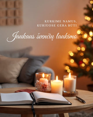 Šilta Kalėdų atmosferos svetainė: ant medinio stalo dega žvakės ir guli atversta knyga, už jos – minkšta sofa su pagalvėlėmis; fone švelniai šviečia papuošta eglutė ir ant sienos pakabintas advento kalendorius su girlianda. GERA NAMIE